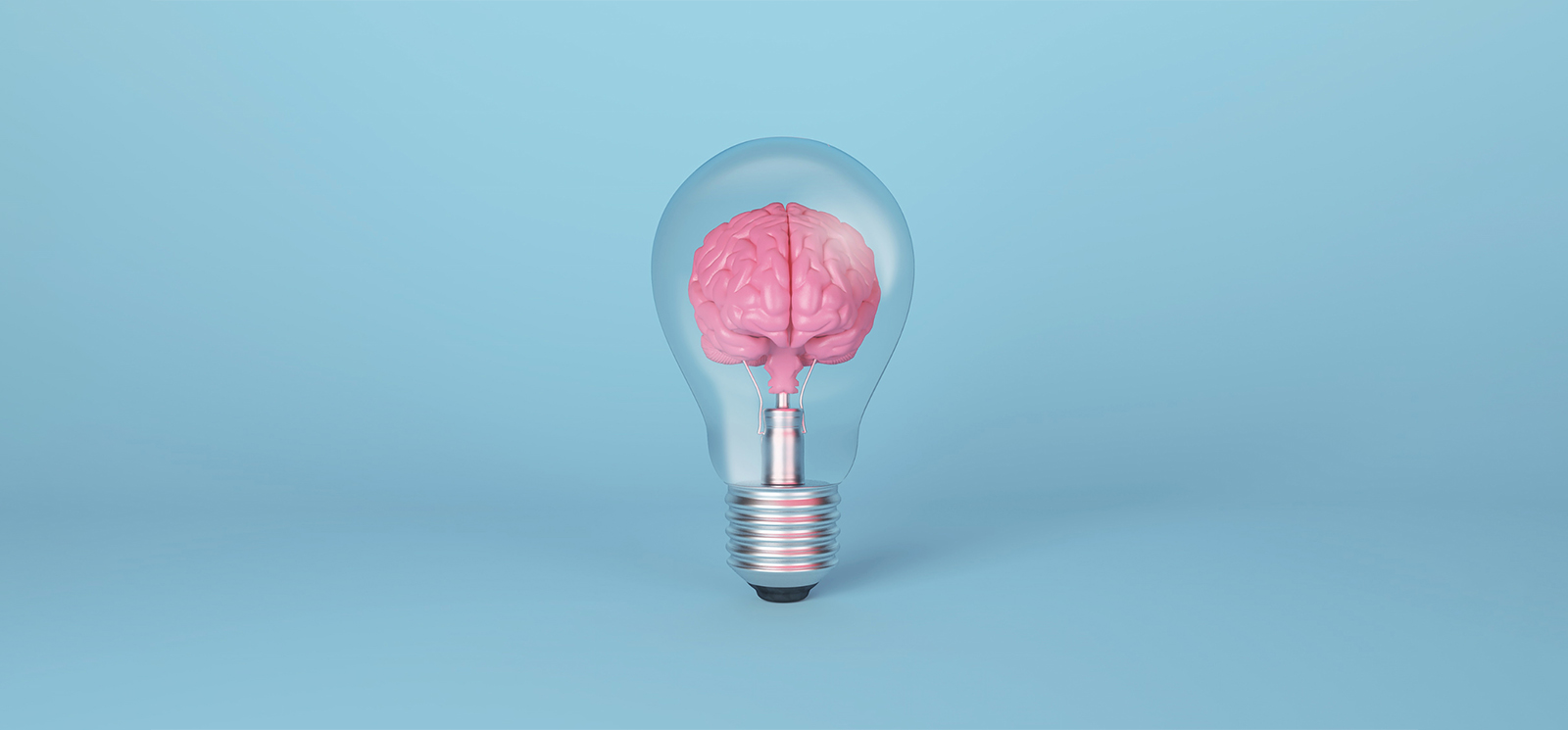a light bulb containing a pink brain on a light blue background