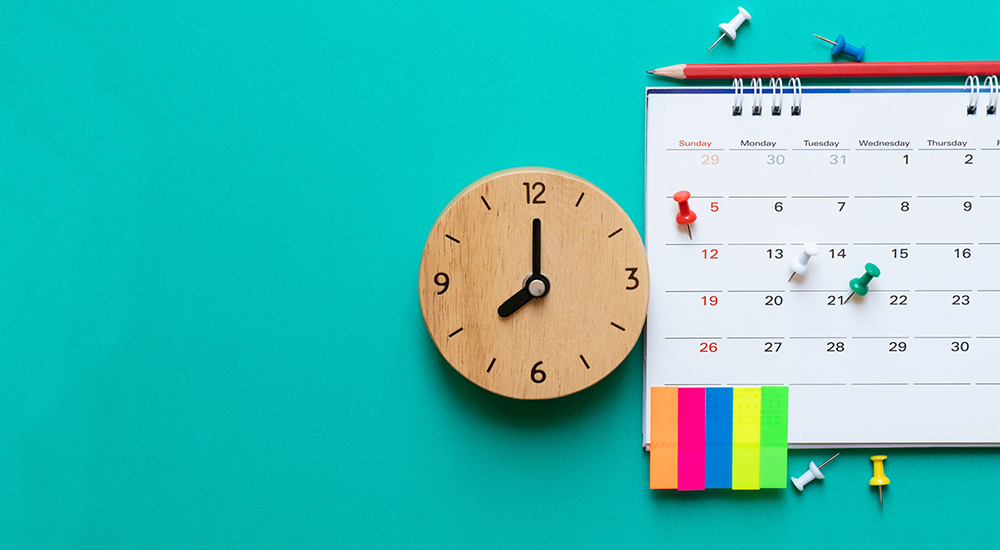 Photo of a wall clock and wall calendar on a turquoise background