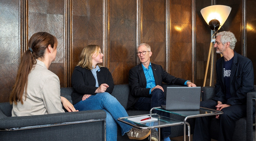 Photo of four people in a discussion group