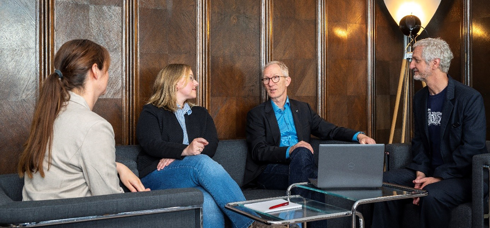 Photo of four people in a discussion group